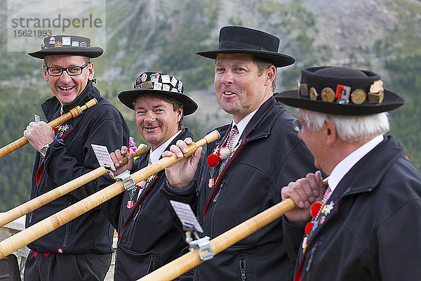 Vier traditionell gekleidete Einheimische aus Zermatt spielen vor dem Matterhorn auf dem Alphorn. Im Laufe der Zeit verschwand das Alphorn als Instrument der Schweizer Hirten fast völlig. Erst mit der Romantik des 19. Jahrhunderts und der Wiederbelebung von Folklore und Tourismus erlebte das Alphorn eine Renaissance und wurde sogar zu einem nationalen Symbol.