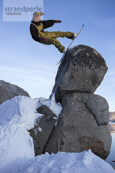 Ein Snowboarder macht einen Sprung über einen Granitfelsen am Nordufer von Tahoe.