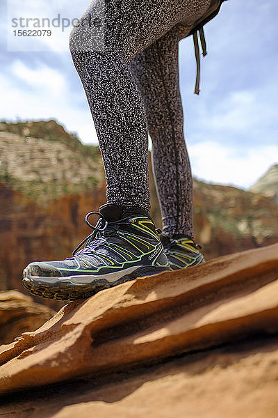 Wanderschuhe an den Beinen einer auf einem Felsen stehenden Frau  Zion National Park  Utah  USA