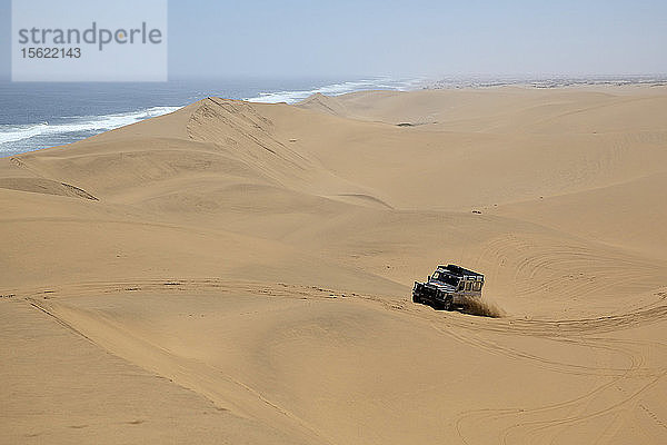 Ein Geländewagen erklimmt eine afrikanische Düne