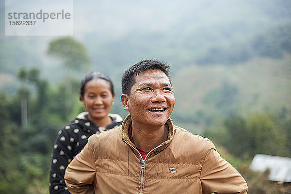 Ein junges Paar steht freudestrahlend vor dem künftigen provisorischen Standort seines Hauses oberhalb von Muang Va  Laos. Das Dorf wird durch den Staudamm Nr. 6 des Nam Ou-Flusses vollständig überflutet werden  und die von der Regierung vorgesehene Umsiedlung in der Nähe von Hat Sa wird nicht rechtzeitig abgeschlossen sein.