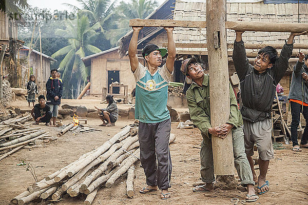 Männer justieren die Position der Stelzen für ein neues Haus  das in Ban Pak Luang  Laos  gebaut wird. Die erhöhten Stelzen schützen vor Schlamm und Überschwemmungen in der Regenzeit. Das Dorf würde durch den geplanten Staudamm Nr. 3 (mit dessen Bau noch nicht begonnen wurde) nur geringfügig überflutet werden.
