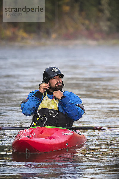 Bärtiger Mann setzt beim Kajakfahren auf dem Snake River einen Helm auf  Jackson Hole  Wyoming  USA