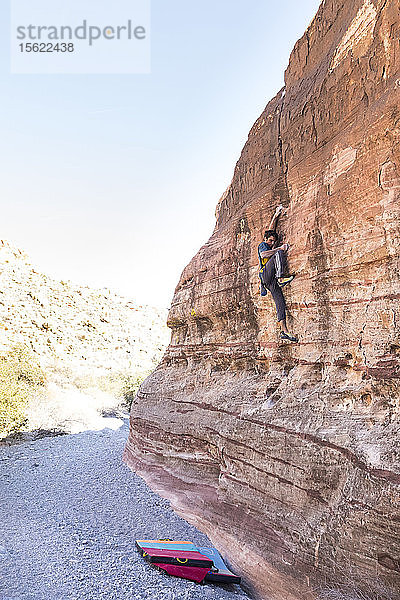 Ein Mann klettert allein auf eine hohe Wand im Red-Rocks-Nationalpark  Nevada