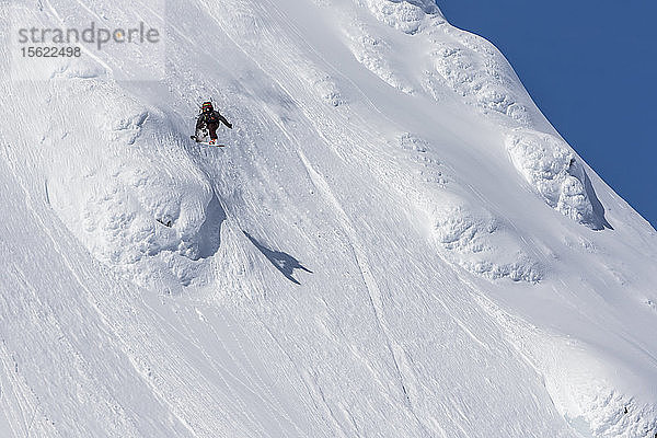 Snowboarder fängt Luft und schnappt sich ihr Brett beim Reiten einer Linie im Norden von British Columbia