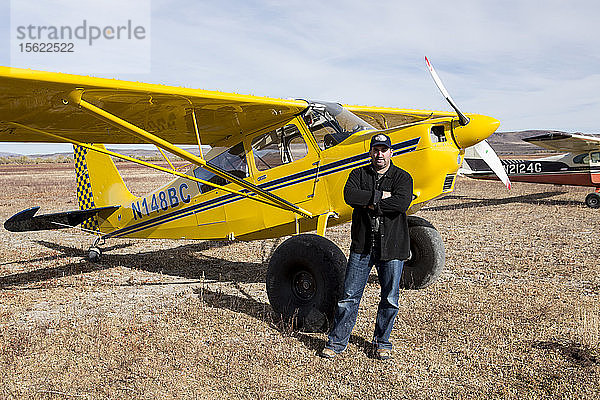 Ein Pilot posiert vor seinem gelben Flugzeug beim High Sierra Fly In