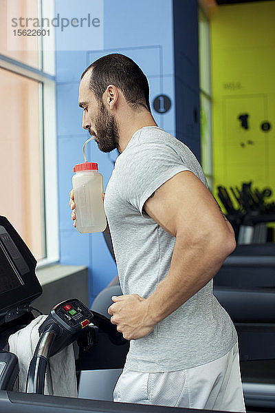 Muskulöser Mann läuft auf einem Laufband in einem Fitnessclub  Sport im Fitnessclub