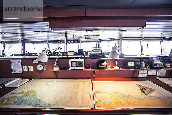 Karten liegen auf einem Tisch auf dem Navigationsdeck eines Containerschiffs.