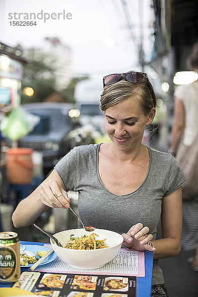 Eine Frau isst eine Nudelschale namens Kao Soi an einem Essensstand im Freien in Chiang Mai  Thailand  am 30. April 2015.