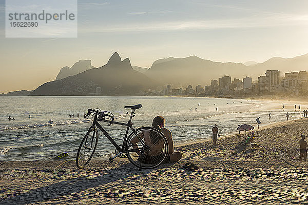 Einheimische entspannen sich am Sandstrand von Ipanema in der Abenddämmerung  Rio de Janeiro  Brasilien.