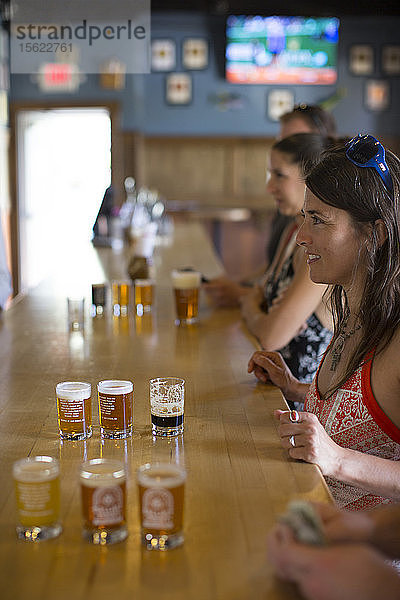 Eine Frau probiert eine Reihe von Bieren im Verkostungsraum von Ballast Point in Miramar  Kalifornien.