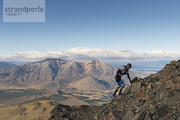 Mann klettert auf felsigen Berg gegen Wolken und Himmel  Esquel  Chubut  Argentinien