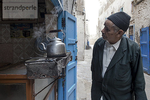 Marokkanischer Mann  der in einem alten Teeladen in der alten Medina beobachtet.
