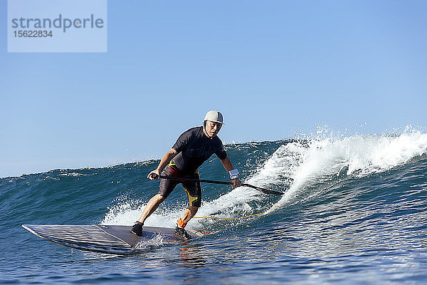 Volle Länge Schuss von einzelnen Paddel Surfer Reiten Welle