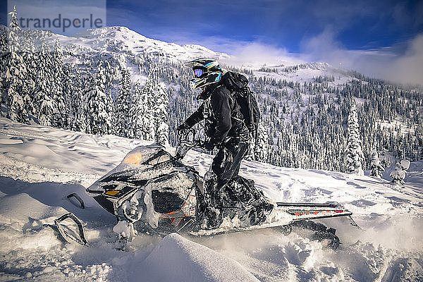 Seitenansicht eines Mannes auf einem Schneemobil im Callaghan Valley  Whistler  British Columbia  Kanada