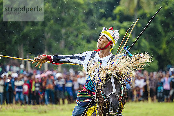 Mann wirft Speer und reitet Pferd beim Pasola-Festival  Insel Sumba  Indonesien