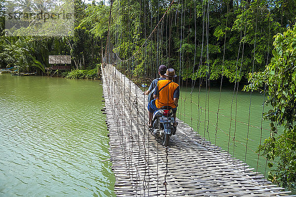 Zwei Männer fahren Motorrad auf einer Hängebrücke