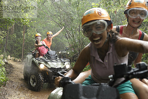 Lachende Frauen beim Quadfahren im Emotions Native Park bei Regen  Quintana Roo  Mexiko