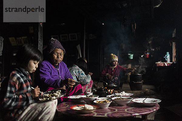 Drei-Generationen-Familie beim gemeinsamen Essen in einem kleinen ländlichen Haus  Myanmar  Shan  Myanmar