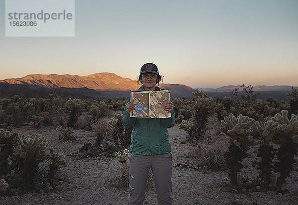 Porträt einer Frau  die im Chollah-Kaktusgarten steht und einen Reiseführer hält  Kalifornien  USA
