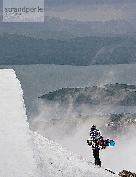 Ein Snowboarder auf verschneiter Landschaft am Cerro Catedral in Argentinien
