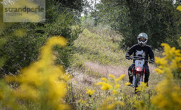 Vorderansicht eines Mannes auf einem Motorrad im Wald