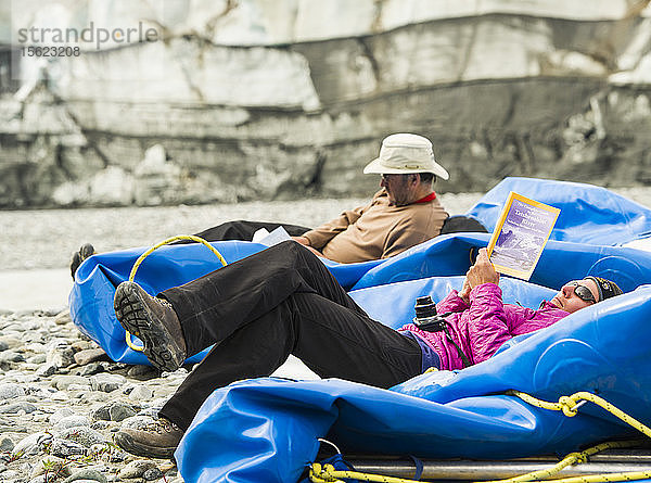Flößer liest Reiseführer während er sich auf dem Floß ausruht