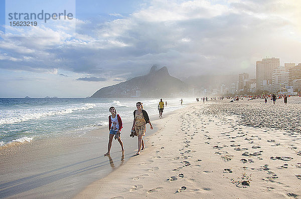 Zwei junge Frauen gehen am Strand von Ipanema  Rio De Janeiro