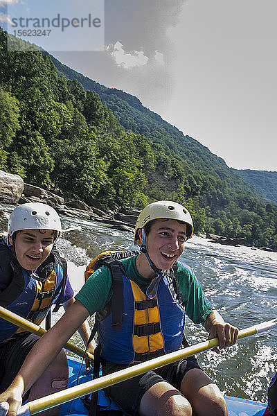 Noah Lopez (vorne) und Patrick Bonorden  Pfadfinder des Pfeilordens  haben viel Spaß bei einer Floßfahrt durch die Stromschnellen des New River während eines Wildwasserabenteuers in der New River Gorge in der Nähe von Fayetteville  außerhalb des Summit Bechtel Reserve (SBR)  WV. Die OA-Pfadfinder nehmen an einem Dienst- und Abenteuerprogramm im SBR teil.