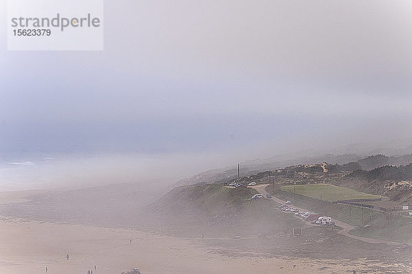 Blick auf Sandstrand und Hügel im Nebel am Morgen  Nazare  Leiria  Portugal
