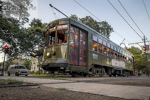 Eine Trolley-Straßenbahn fährt an einer Kreuzung von Straßen im Gartenviertel von New Orleans  Louisiana  USA vorbei