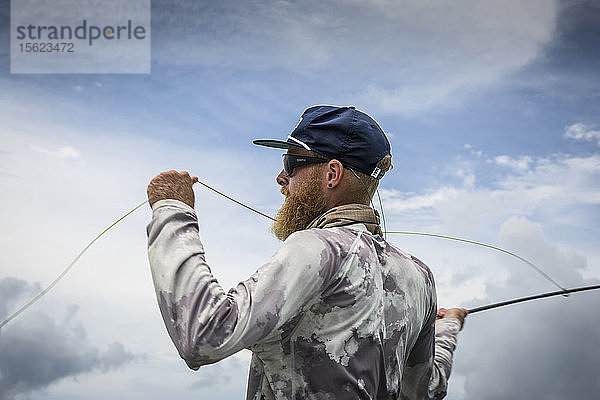 Der Angler Jonathan Jones wirft beim Fischen in den Tropen von Samoa.