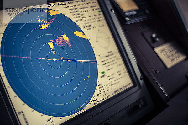 Radaranzeige auf einer elektronischen Karte auf dem Navigationsdeck eines Containerschiffs auf See.