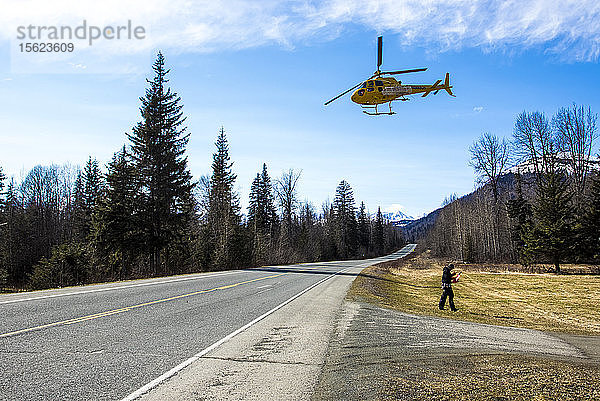 Ein Hubschrauber  der Skifahrer und Snowboarder auf die Gipfel der Berge bringt  hebt an einem Frühlingstag in Haines  Alaska  vom Hubschrauberlandeplatz ab  um in den Schnee zu fliegen.