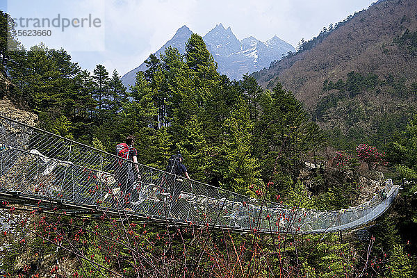 Bergsteiger beim Überqueren einer Hängebrücke auf dem Weg zum Mount Everest Base Camp