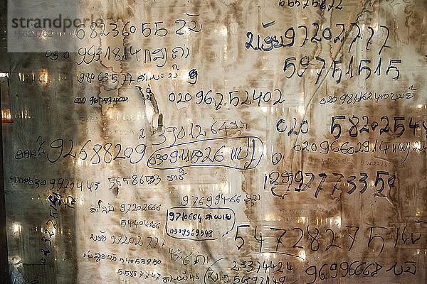 Telefonnummern an der Wand eines Hauses in Ban Huay Phouk  Laos.