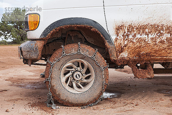 Moab Outfitter Van mit Reifenketten auf der schlammigen Straße nach Mineral Bottom  Utah.