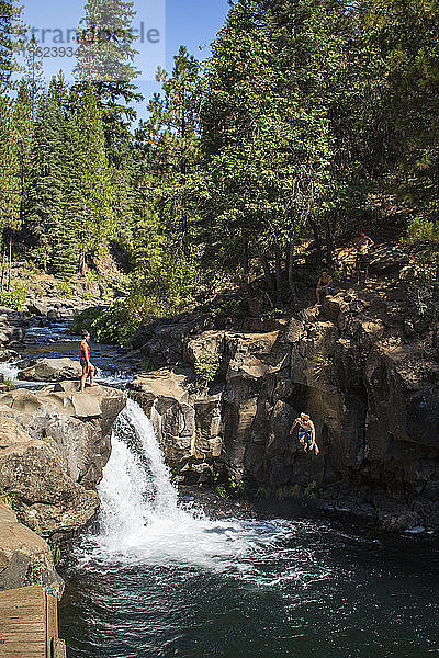Abenteuerlustiger Mann beim Klippenspringen in der Nähe eines Wasserfalls am McCloud River  Kalifornien  USA