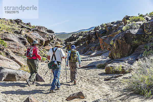 Drei Personen  die im Little Petroglyph Canyon  Ridgecrest  Kalifornien  USA  auf Sand laufen