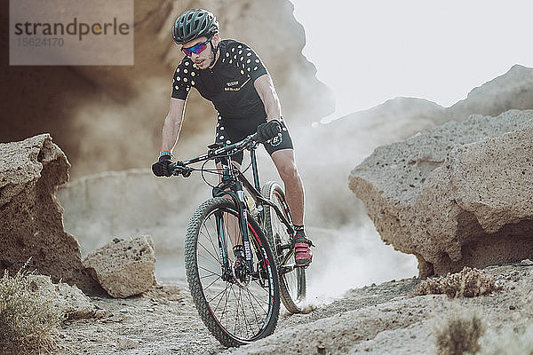 Mann fährt mit seinem Mountainbike in der Wüste  Teneriffa  Kanarische Inseln  Spanien