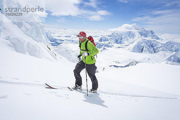 Ein Skitourengeher auf dem Kahiltna-Gletscher im Denali-Nationalpark in Alaska. Im Hintergrund ist der Mount Foraker zu sehen.