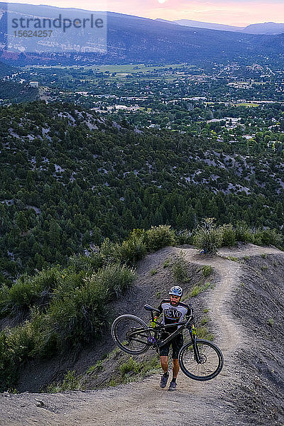 Männlicher Mountainbiker in malerischer Landschaft trägt Fahrrad auf den Hogs Back in der Nähe von Durango  Colorado  USA