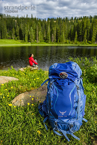 Fernansicht eines Rucksacktouristen  der sich am Seeufer ausruht  mit Rucksack im Vordergrund  Bolam Pass  Colorado Trail  Colorado  USA