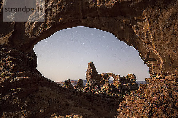 Mondlicht beleuchtet den Turret Arch durch das North Window im Arches National Park.