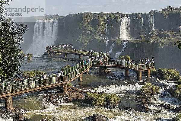 Große Gruppe von Touristen auf einer Brücke  die die schöne Landschaft der Iguazuï¾-Wasserfälle genießen  Parana  Brasilien