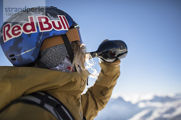 Skifahrer in Skikleidung  der Wein aus einer Flasche trinkt  Monterosa Ski Mountain Resort in Gressoney  Aosta  Italien