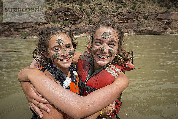 Zwei Kinder spielen im Fluss und bemalen sich gegenseitig mit Schlamm  während sie auf dem Green River Rafting-Trip sind  Desolation/Gray Canyon Section  Utah  USA