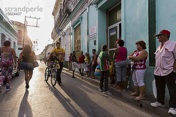 Menschen  die in der Morgendämmerung auf der Straße stehen und gehen  Santiago de Cuba  Kuba