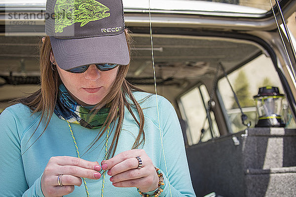 Eine Frau rüstet eine Fliegenrute aus  bevor sie den Gallatin River in Montana befischt.