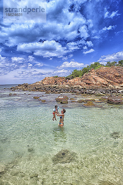 Mutter und Tochter spielen im Meer. Taubeninsel. Sri Lanka